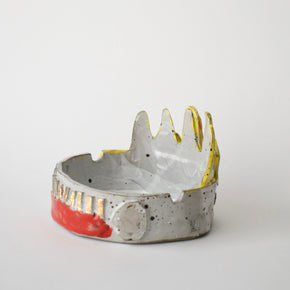 Ceramic bowl with gold and red accents on a white background