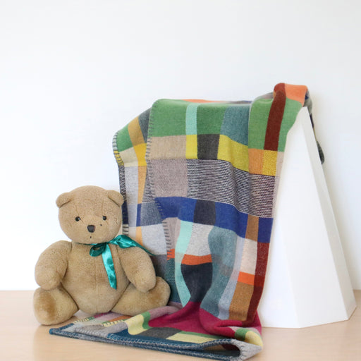 Small size Wallace Sewell Gwynne blanket on stool with teddy bear