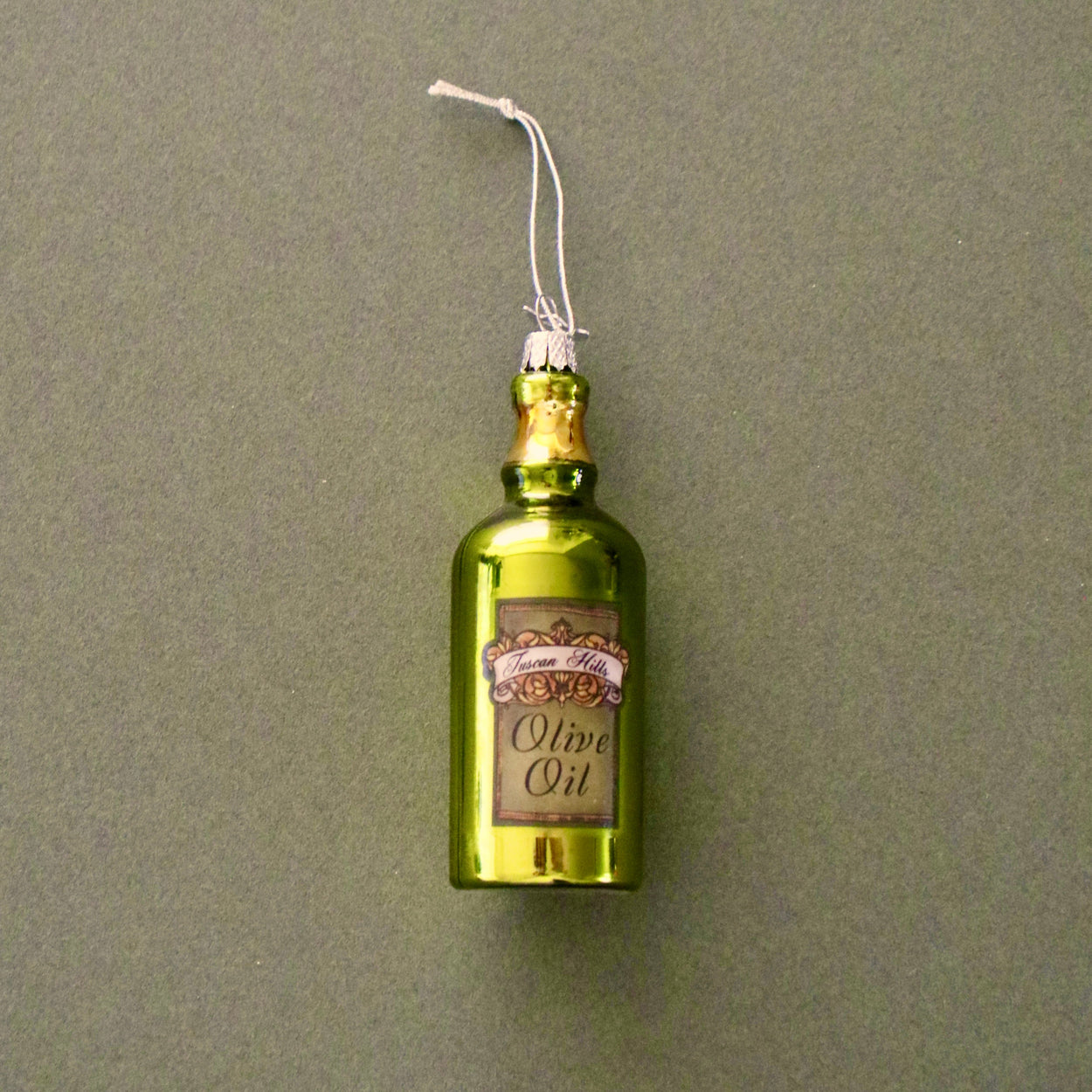 Decorative olive oil bottle ornament on a plain background