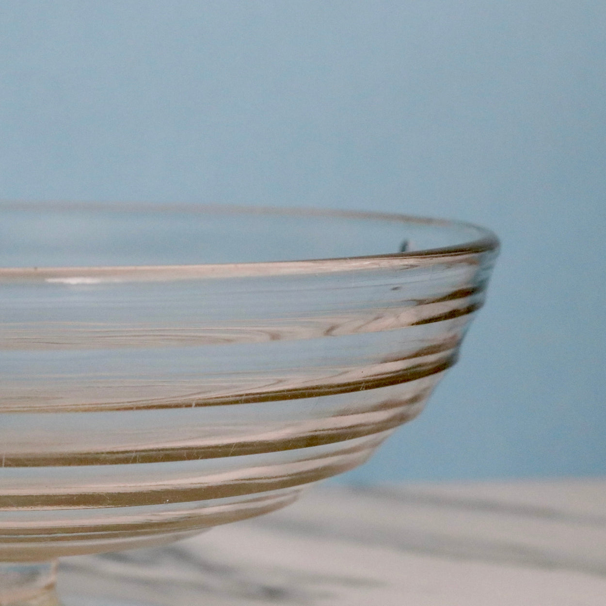 Glass bowl with striped design on a light blue background