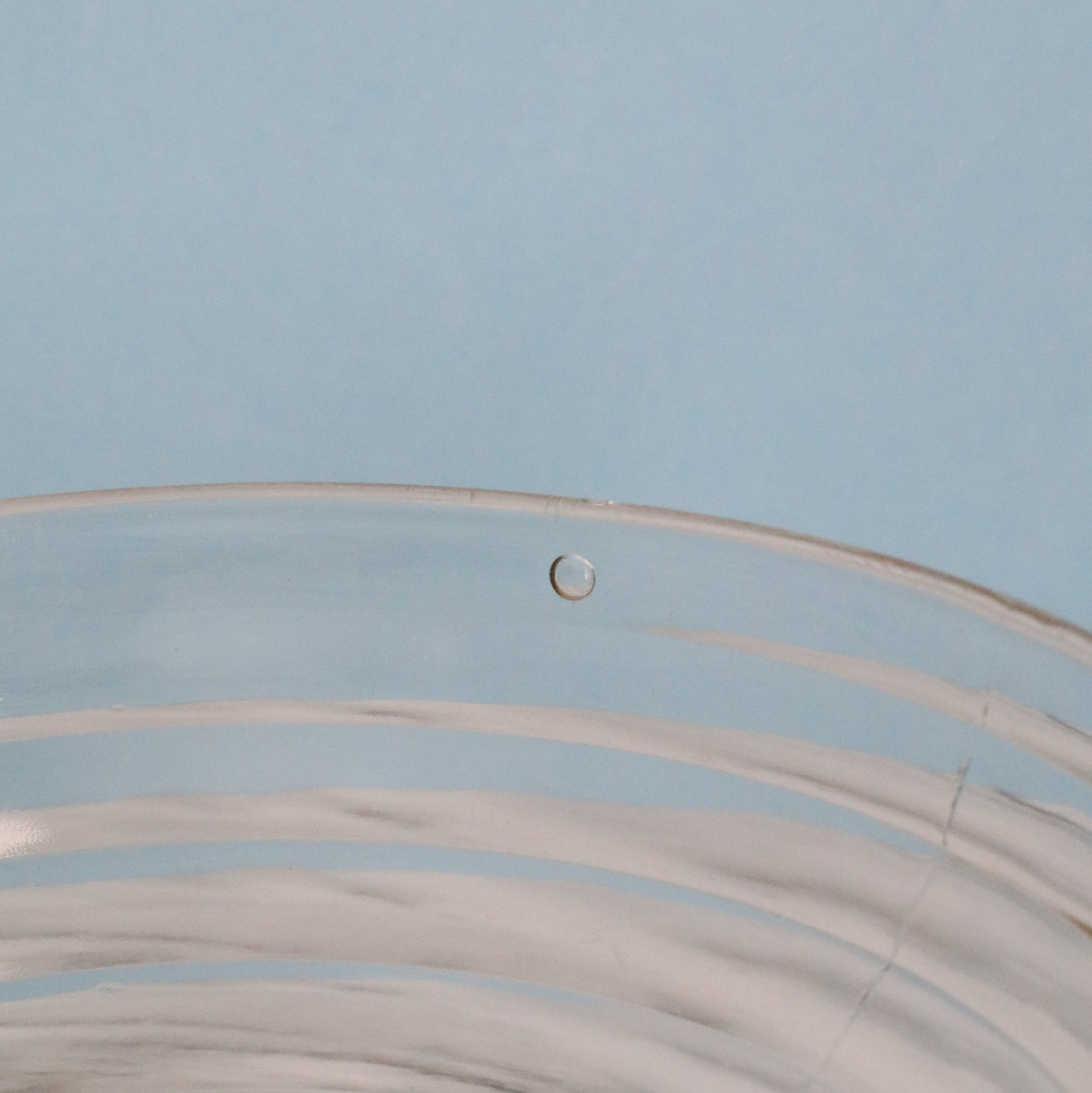 Close-up of a air bubble on glass with a light blue background