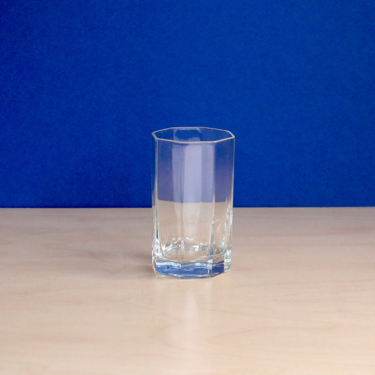 Clear glass on a beige surface with a blue background
