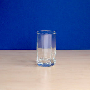 Clear glass on a beige surface with a blue background