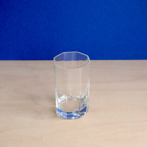 Clear glass on a beige surface with a blue background
