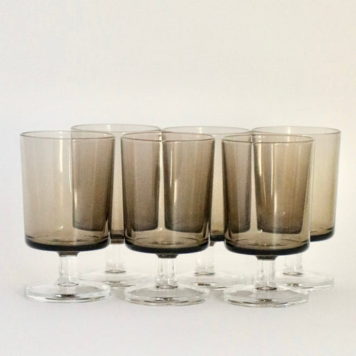 Six Smoked glass tumblers against a white background