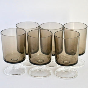 Set of six smoked glass tumblers on a white background