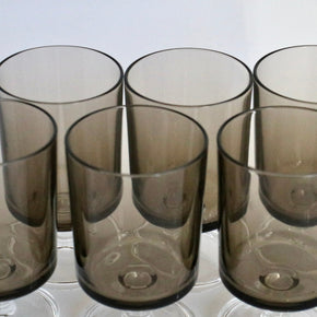 Set of six smoked glass tumblers on a white surface
