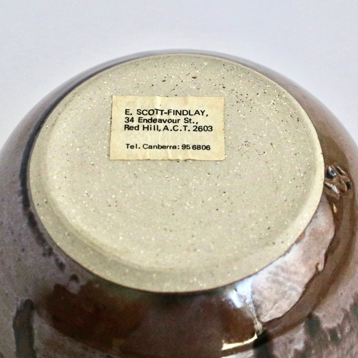 Ceramic pot with a label on a white background