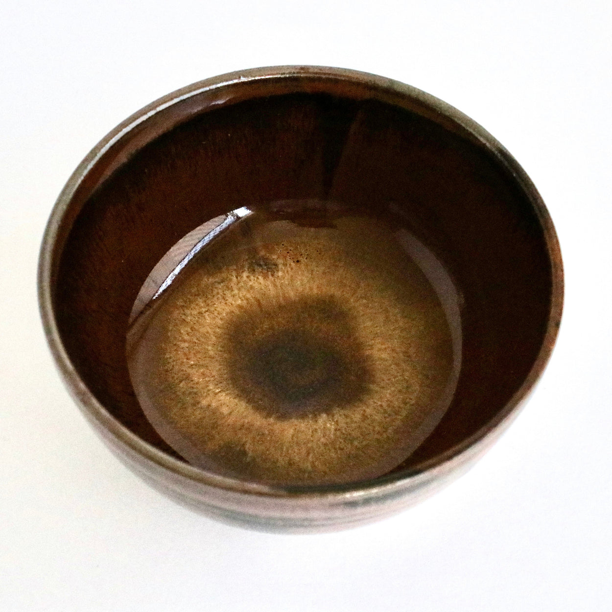 Brown ceramic bowl with a glossy finish on a white background