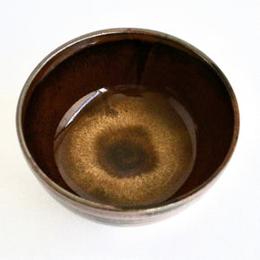 Brown ceramic bowl with a glossy finish on a white background