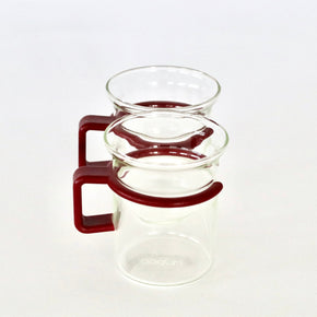 Clear glass coffee mugs with red plastic handles on a white background