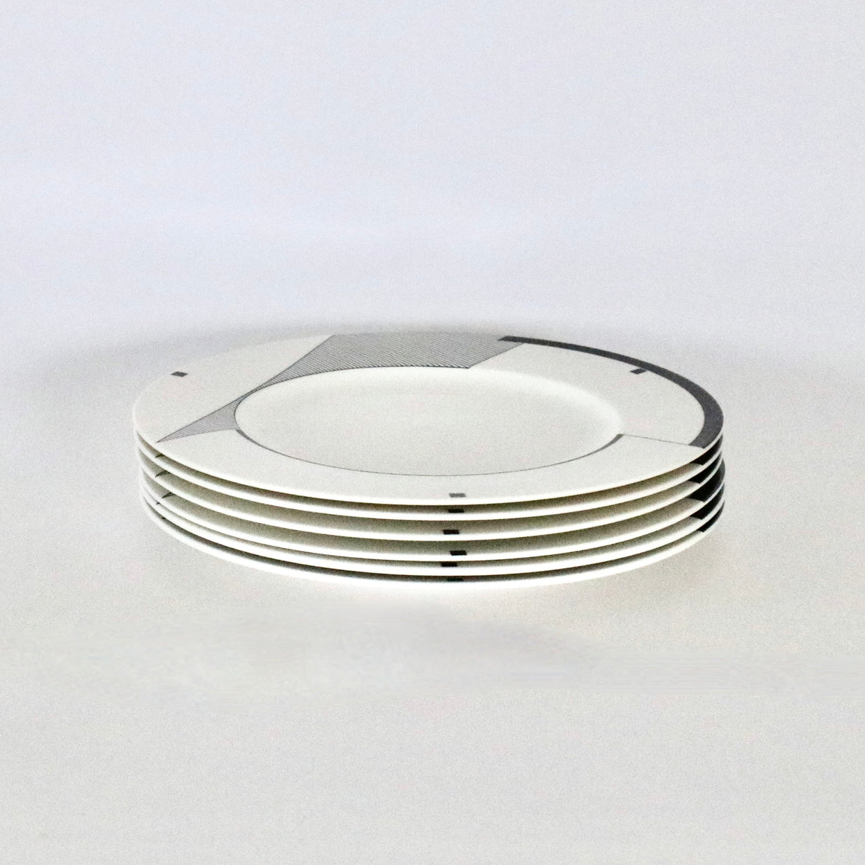 Stack of white ceramic plates on a light gray background