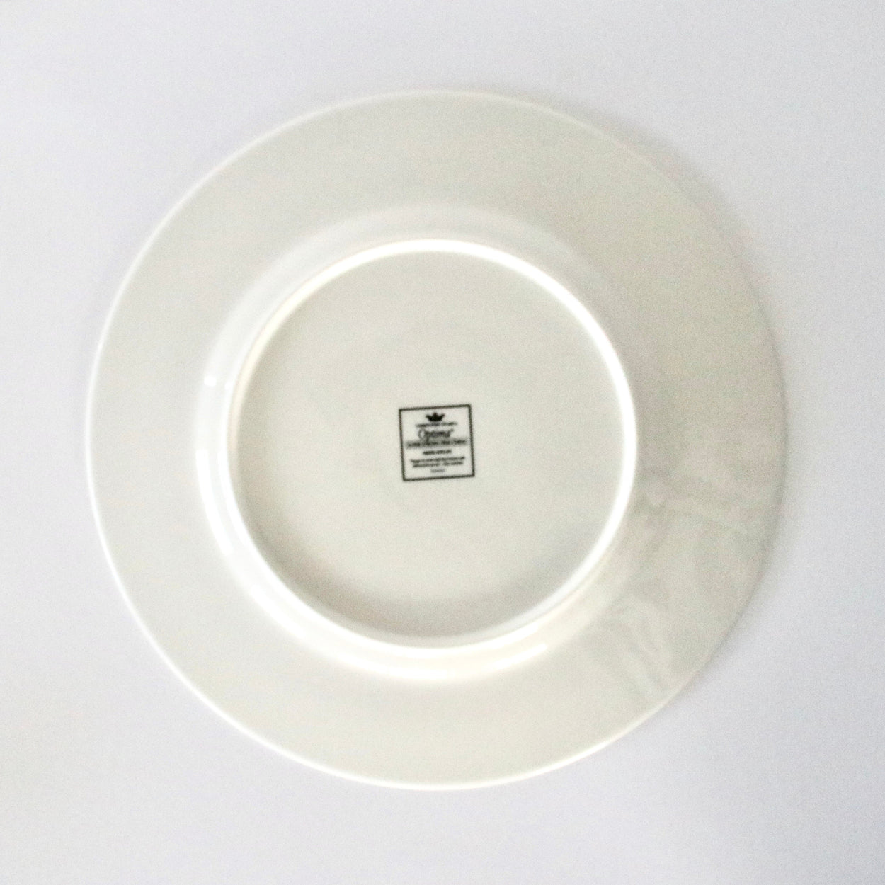 White ceramic plate with a visible brand logo on a white background