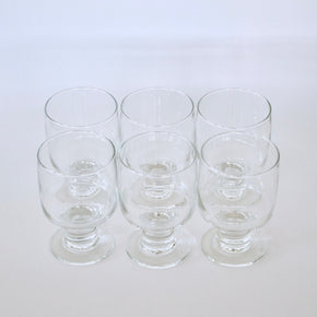 Set of six clear glass tumblers on a white background