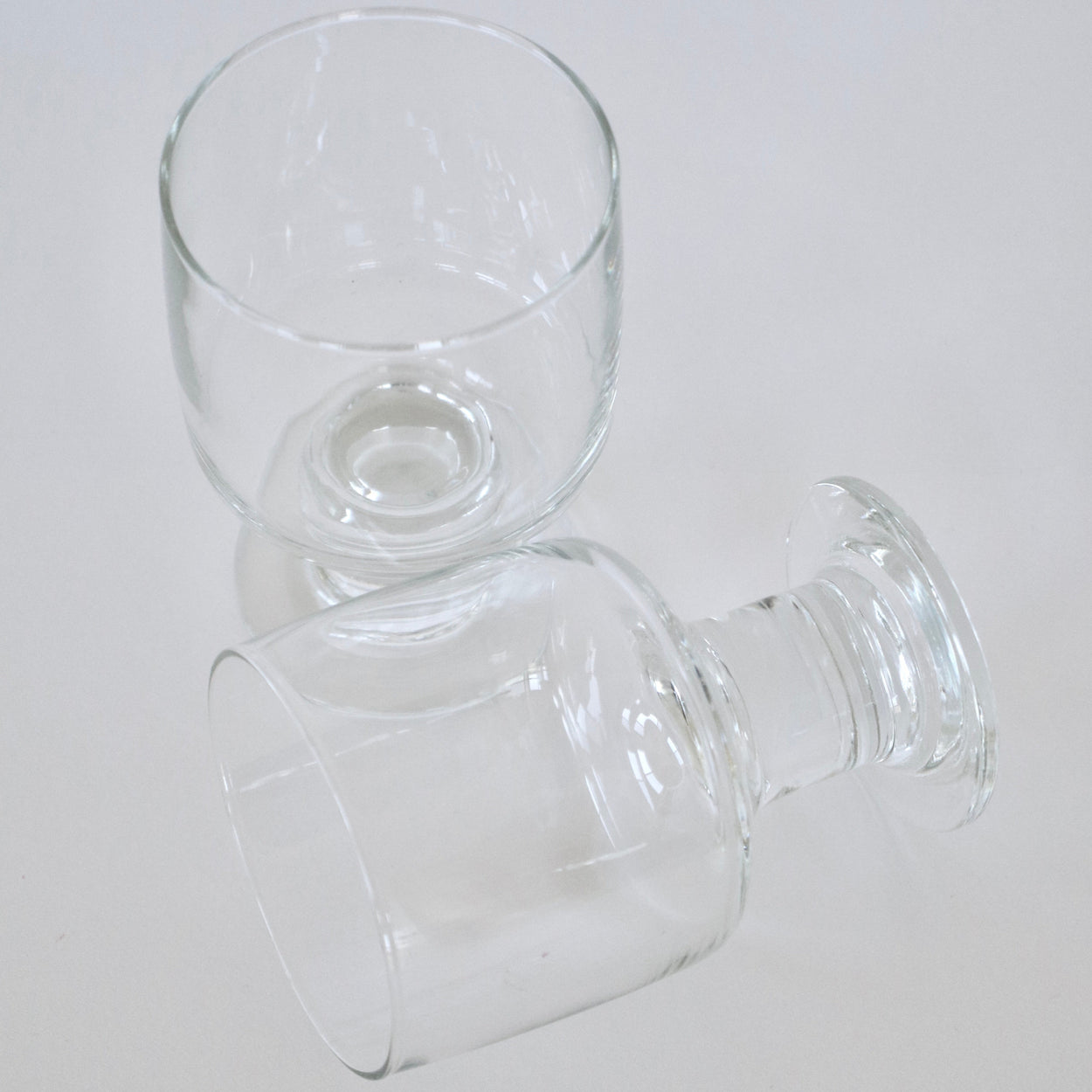 Two clear glass goblets on a white background