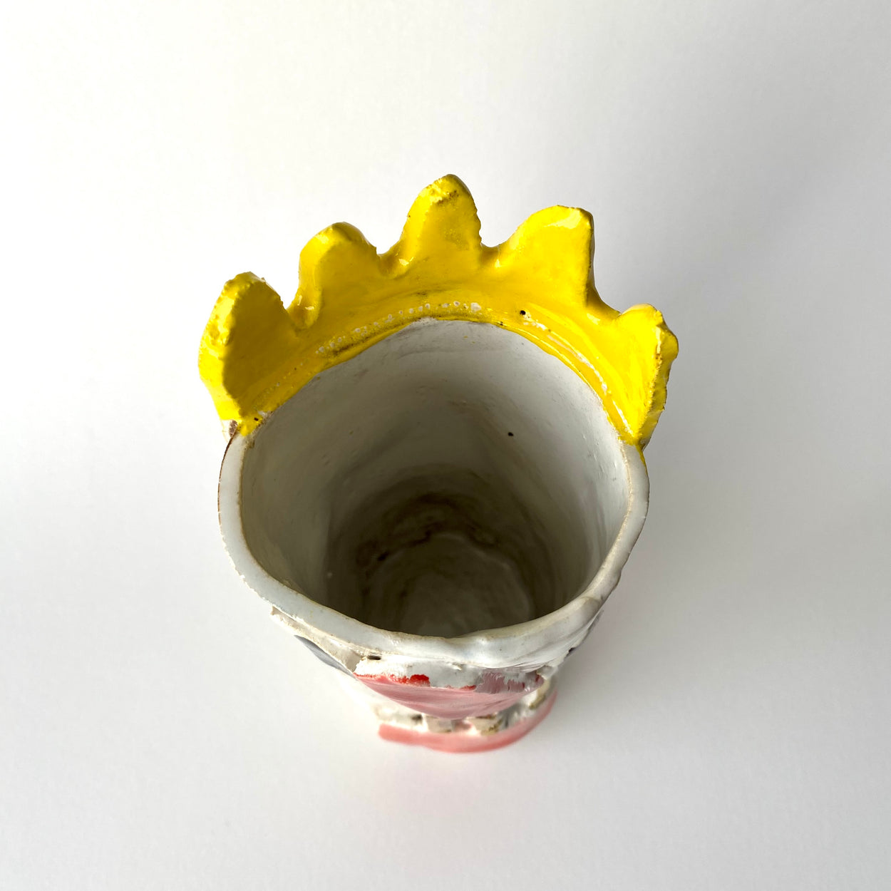Ceramic vase with yellow rim on a white background