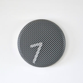 Round metallic clock with a textured surface on a white background