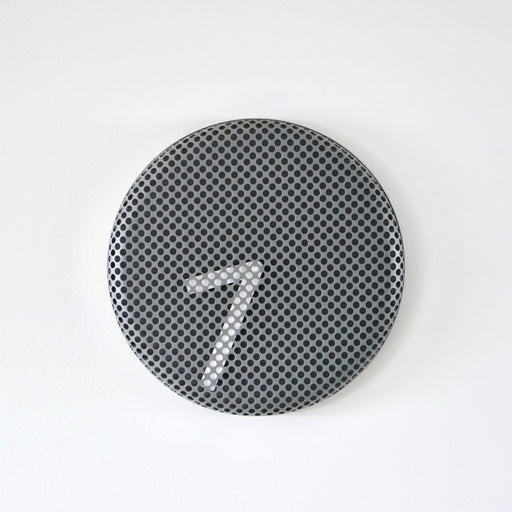 Round metallic clock with a textured surface on a white background
