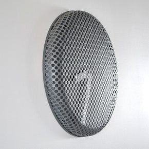 Round metallic clock with honeycomb face on a white background
