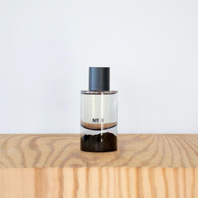Perfume bottle labeled 'No. 8' on a wooden surface with a light gray background