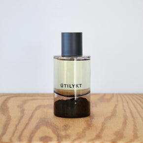 Clear bottle with black cap and label on a wooden surface