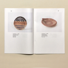 Open book showing two ceramic plates on a beige background