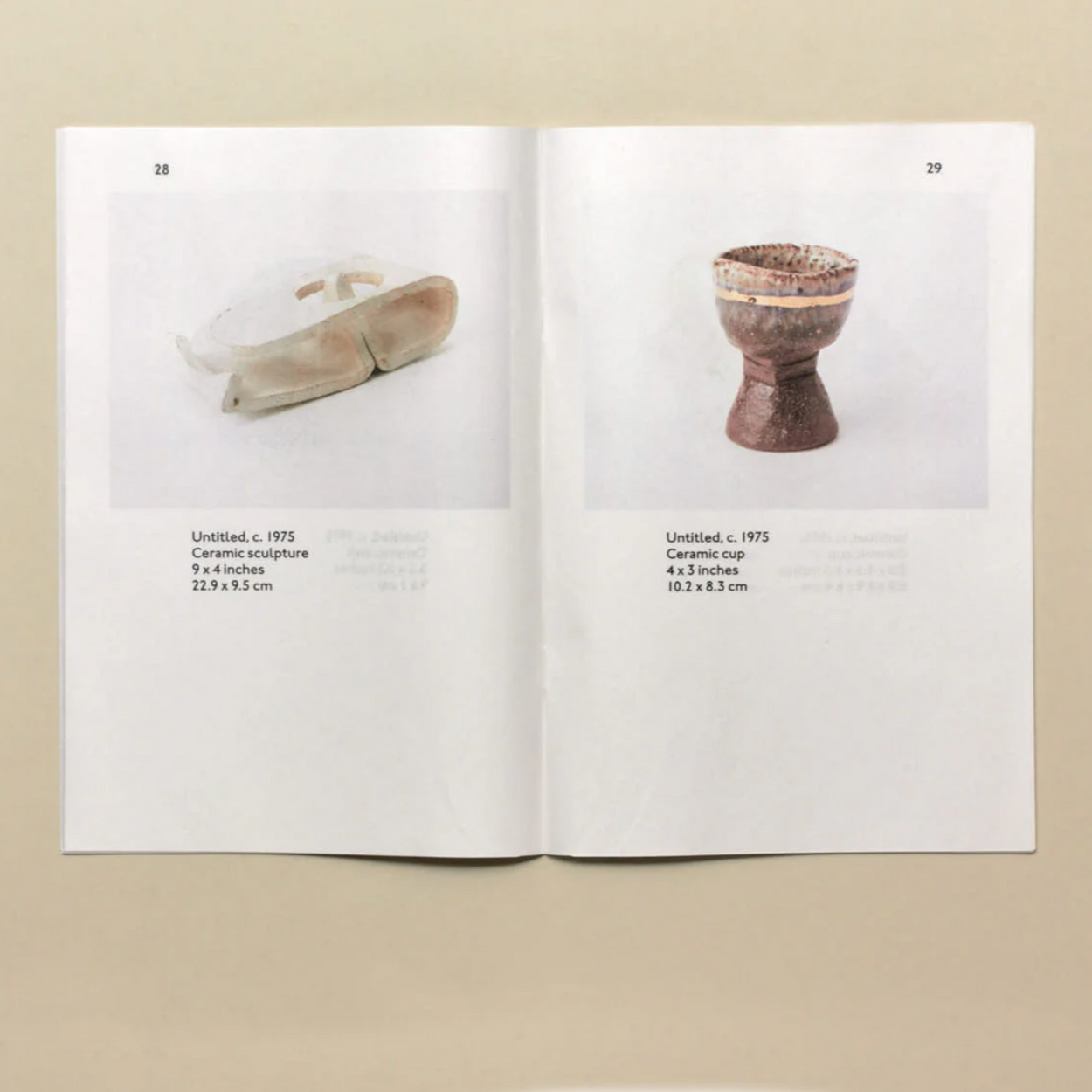 Open book showing images of ceramic objects on a beige background