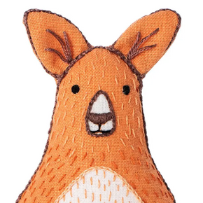 Close up of embroidered Kangaroo face with orange fur, black eyes, and white nose on a white background.