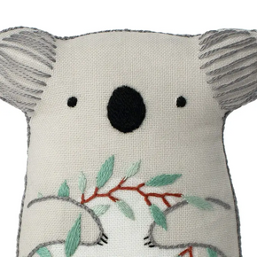 Embroidered koala plushie with leaves on a white background