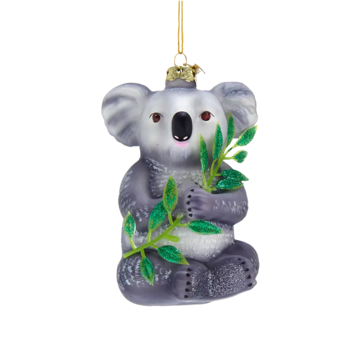 Glass koala ornament holding eucalyptus leaves on a white background