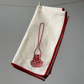White napkin with red embroidered design of a fork and spaghetti on a gray background