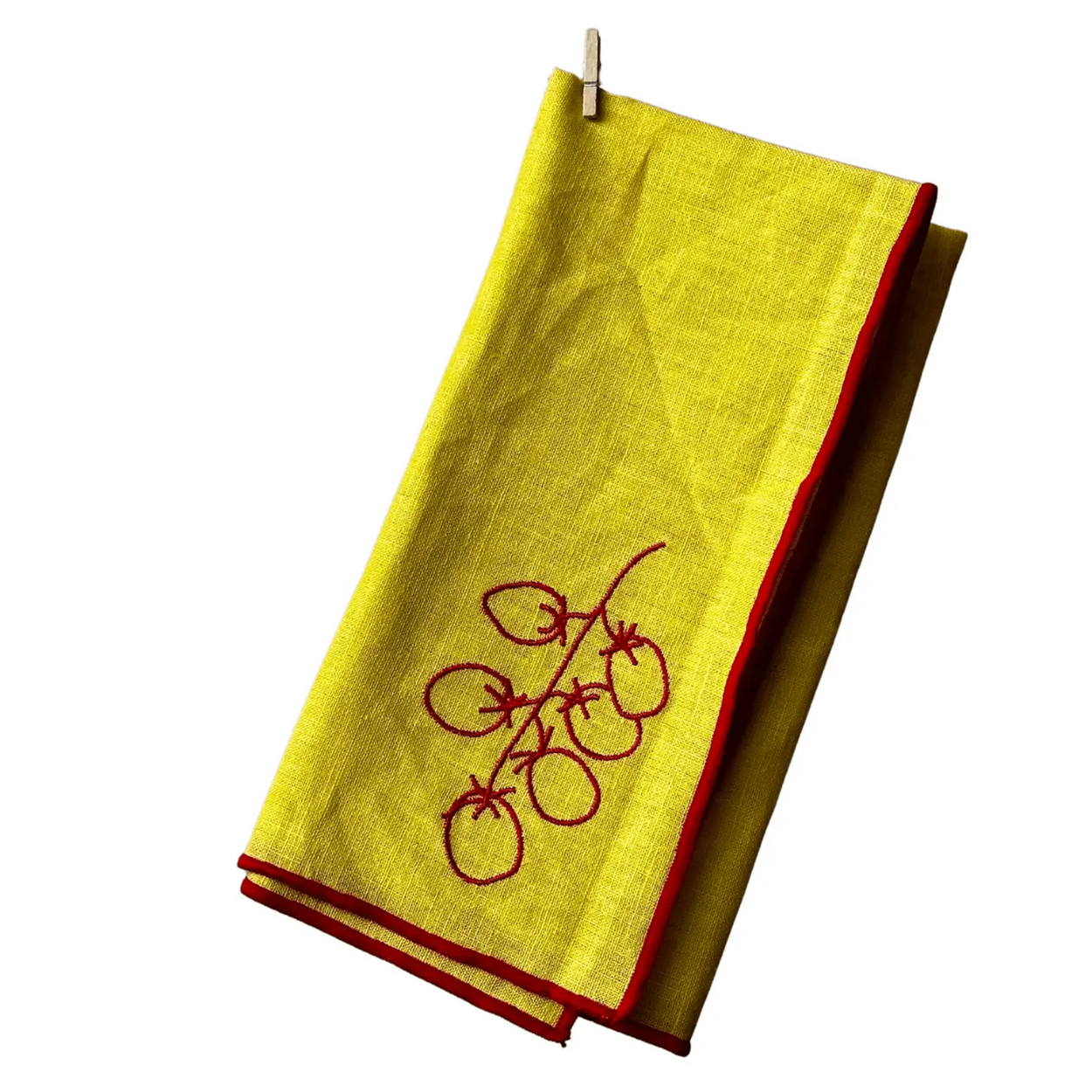 Yellow napkin with red trim and embroidery on a white background