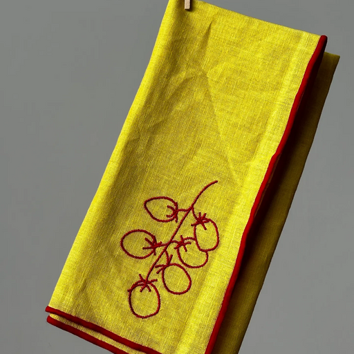 Yellow napkin with red embroidery on a gray background