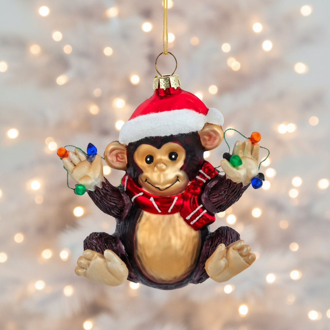 Christmas monkey ornament with a Santa hat and lights on a white background