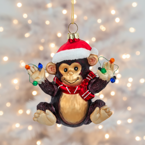 Christmas monkey ornament with a Santa hat and lights on a white background