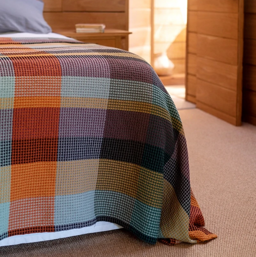 Mungo Vrou-Vrou Cotton Waffle Blanket - Cypress on bed in wood lined room