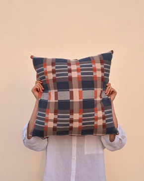 Woman holding blue Mungo Skipping Block Cushion in front of her head for scale.