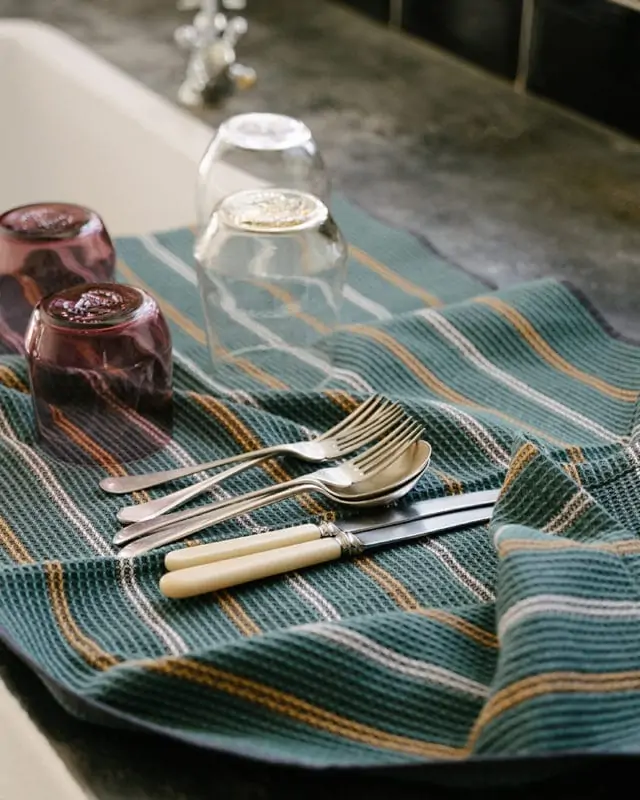 Mungo Waffle Tea Towel in Junipe Green on vintage table with vintage cutlery.