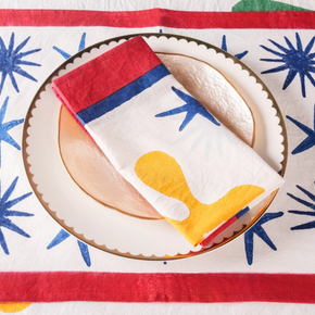 Colorful napkin with a red, white, and blue design folded on a plate against a patterned background.