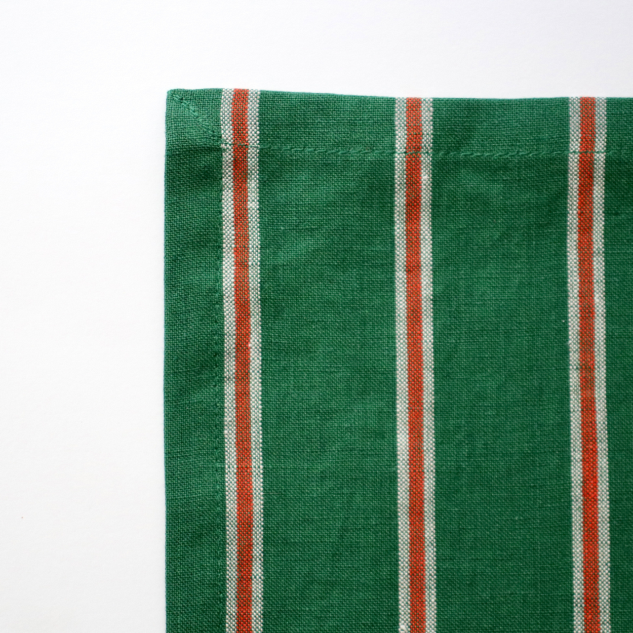 Green fabric with red and white stripes on a white background