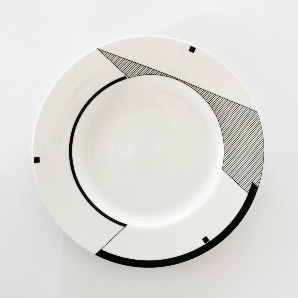 White plate with black geometric design on a white background