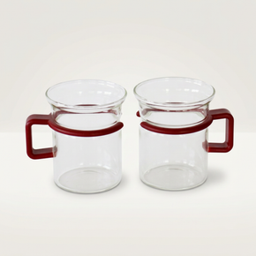 Two clear glass mugs with red handles on a white background