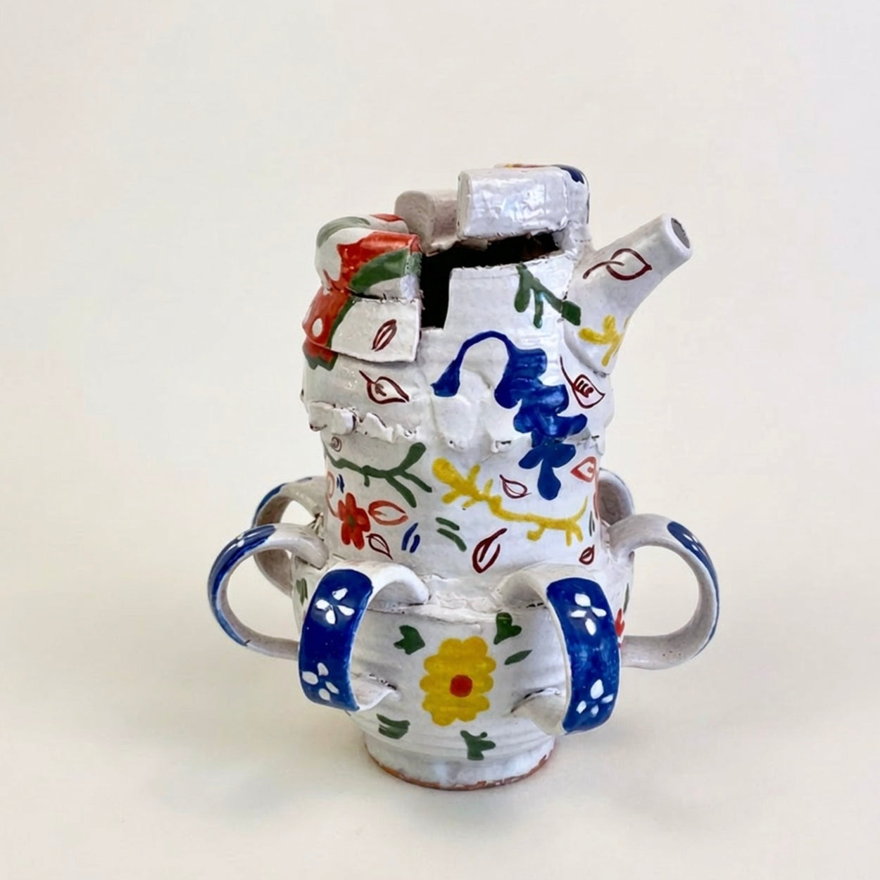 Ceramic teapot with colorful floral patterns on a white background