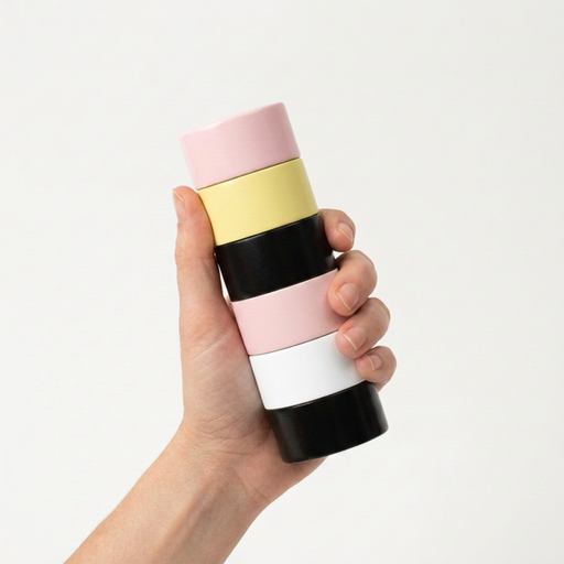 Colorful striped Semi D salt grinder held in a hand against a light gray background