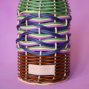 Decorative bottle with woven design on a purple background