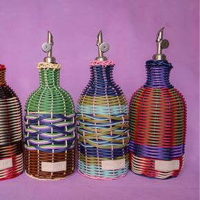 Five colorful woven bottle dispensers on a purple background