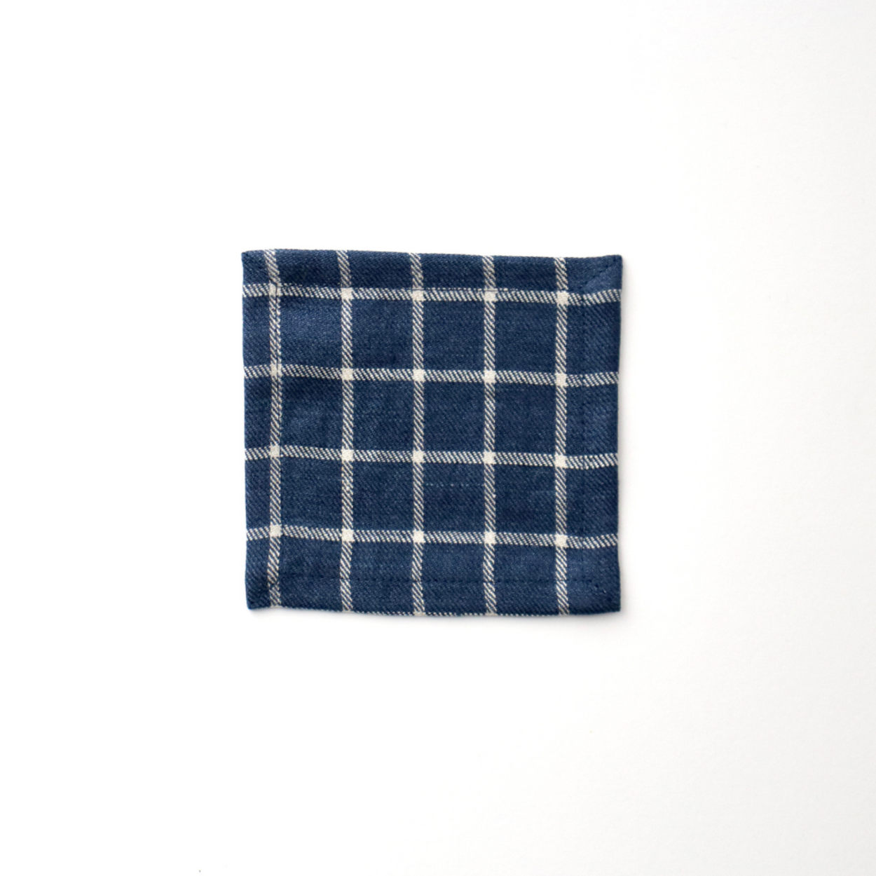 Navy blue and white check Japanese linen coaster on a white background.