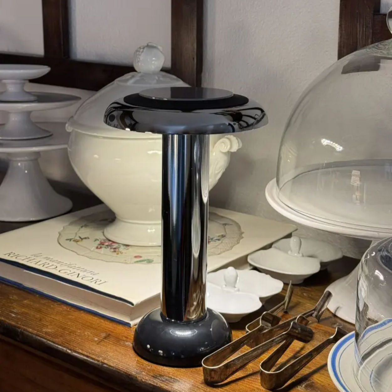 Sowden PL6 Lamp with a white ceramic dish on top, surrounded by books and kitchen items.