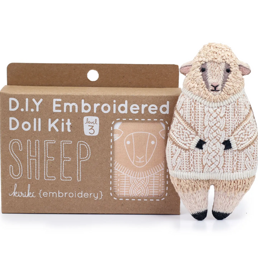 Embroidered doll kit for sheep with a completed embroidered sheep toy on a white background