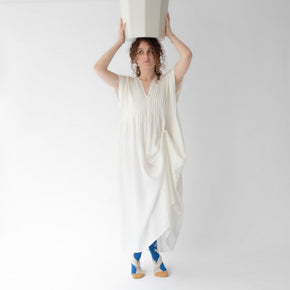 Woman in white dress wearing Statue Bonne Maison socks on white backdrop.